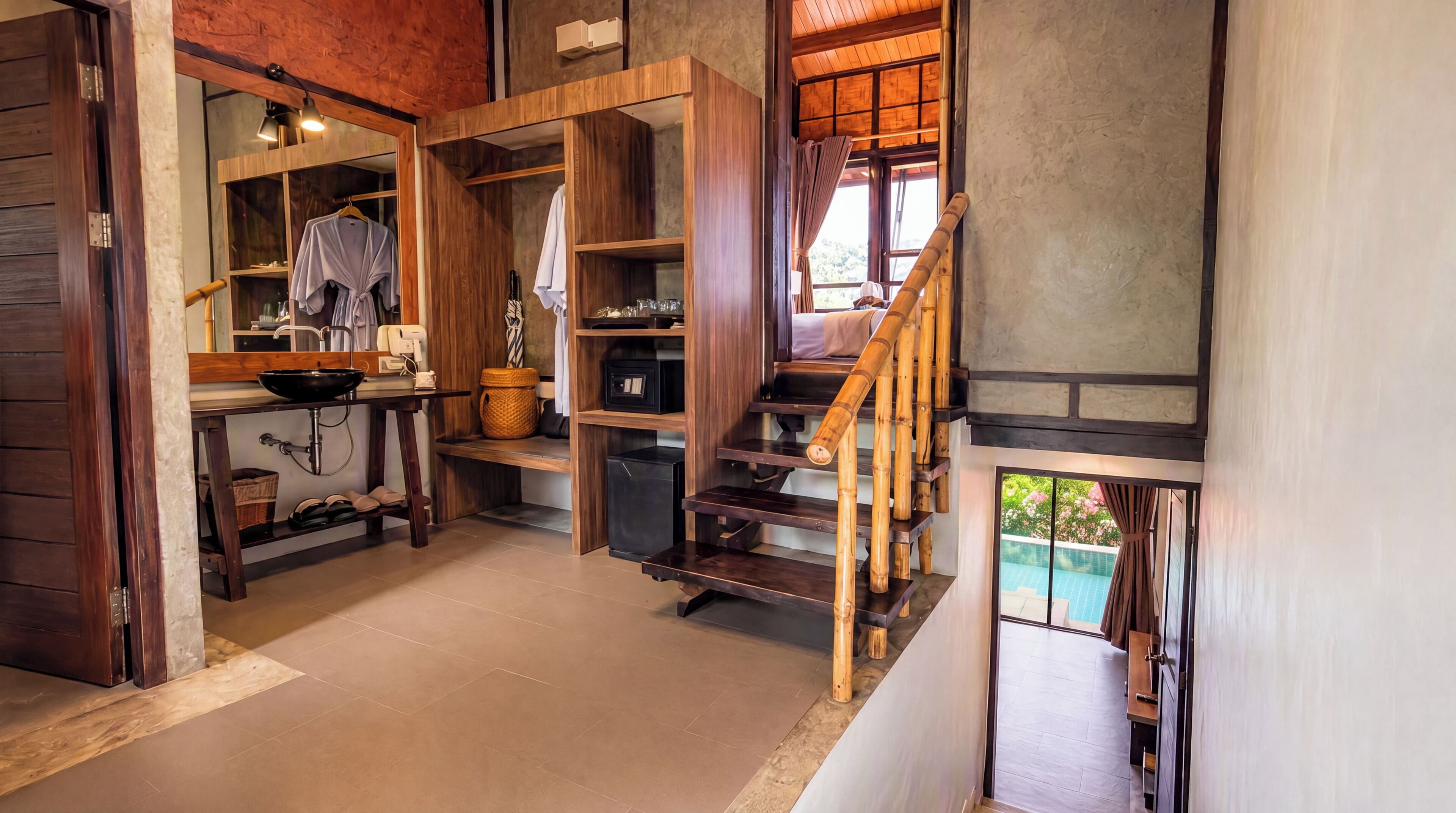 Interior de madera con cocina, una escalera y vista a una piscina.