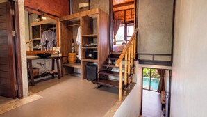 A wooden interior with a kitchen area, a staircase, and a view of a swimming pool. - Alama Sea Village Resort (Ko Lanta)