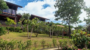 A residential area with a house featuring a balcony, surrounded by lush greenery and trees. - Alama Sea Village Resort (Ko Lanta)