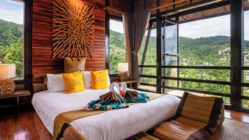 Ein geräumiges Schlafzimmer mit einem großen Bett, einem hölzernen Kopfteil und Blick auf eine üppige Landschaft.