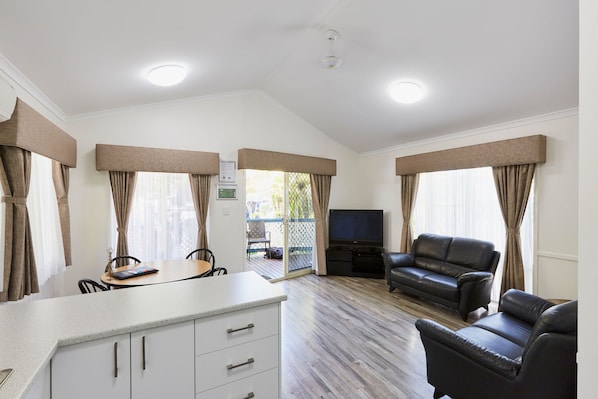 A spacious living area with a dining table, a sofa, and a TV. - Discovery Parks - West Busselton (West Busselton)