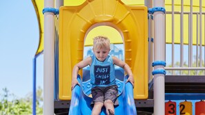 A child on a blue slide at a playground. - Discovery Parks - West Busselton (West Busselton)