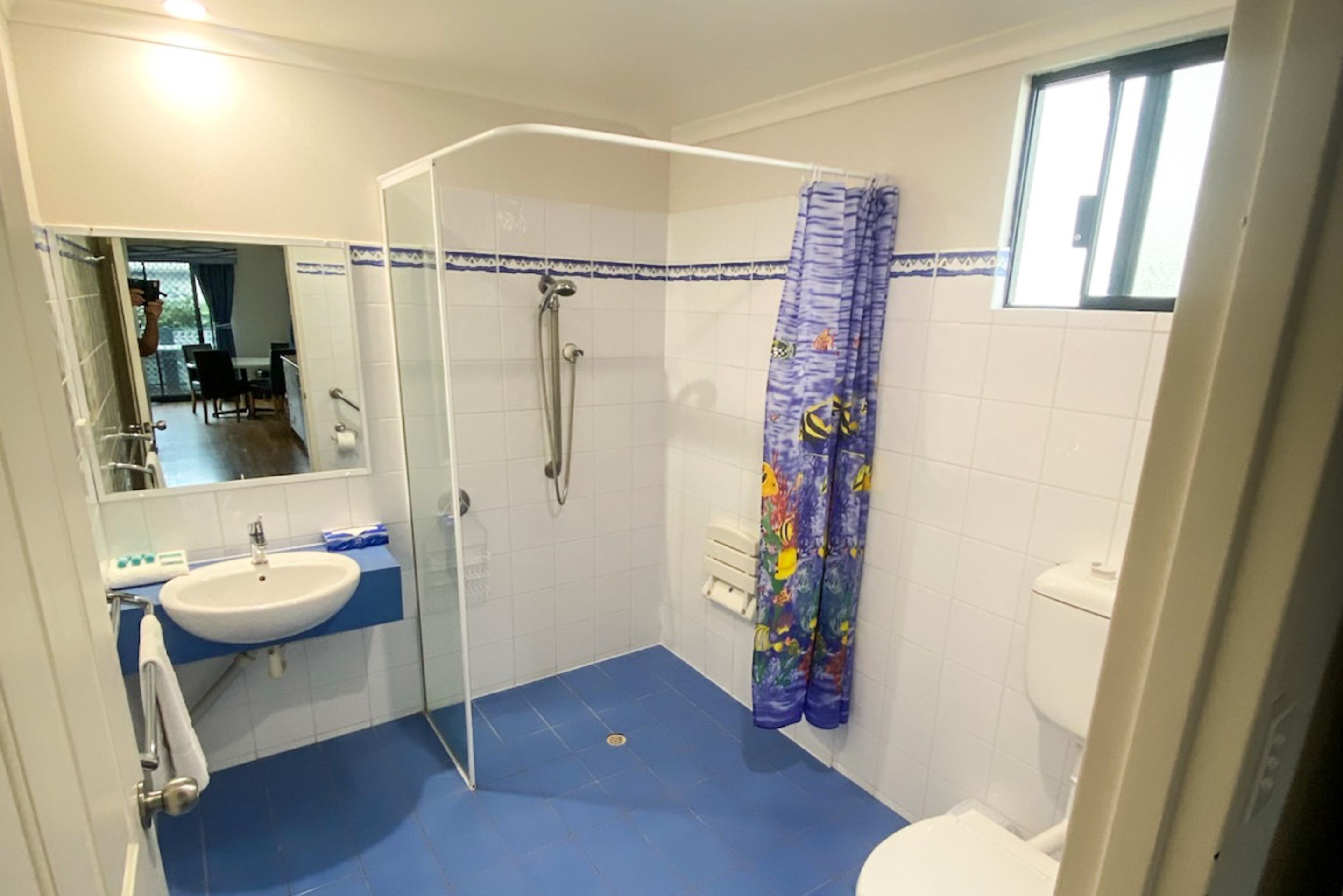 A bathroom with a shower, toilet, and sink.