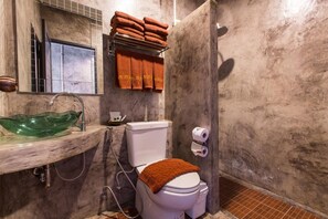 A bathroom with a marble sink, a glass bowl sink, a toilet, and a shower area. - Na Siam Guesthouse (Phuket)