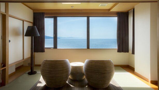 Ein Zimmer mit Tatami-Matten, einem niedrigen Tisch und zwei großen Tatami-Matten.