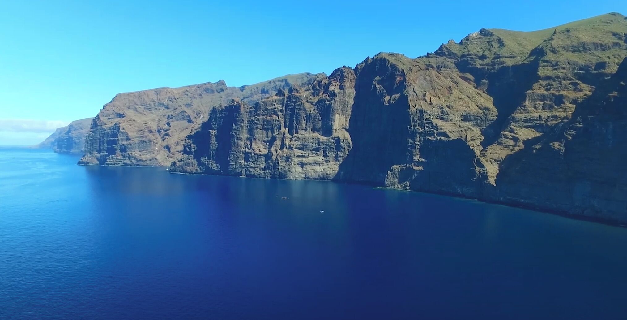 Un paysage côtier caractérisé par de hautes falaises et une mer calme.