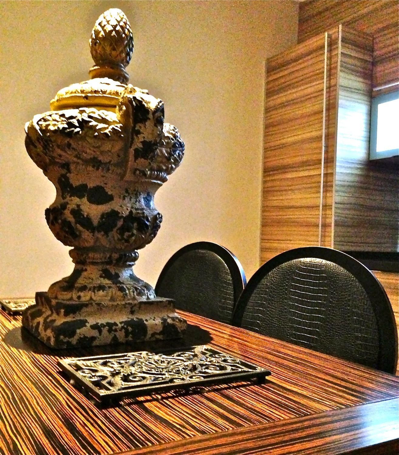 Una mesa de comedor con un centro de mesa decorativo, un mantel individual estampado y dos sillas.