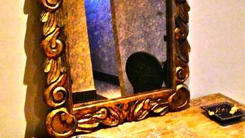 A mirror with an ornate frame on a wooden surface.