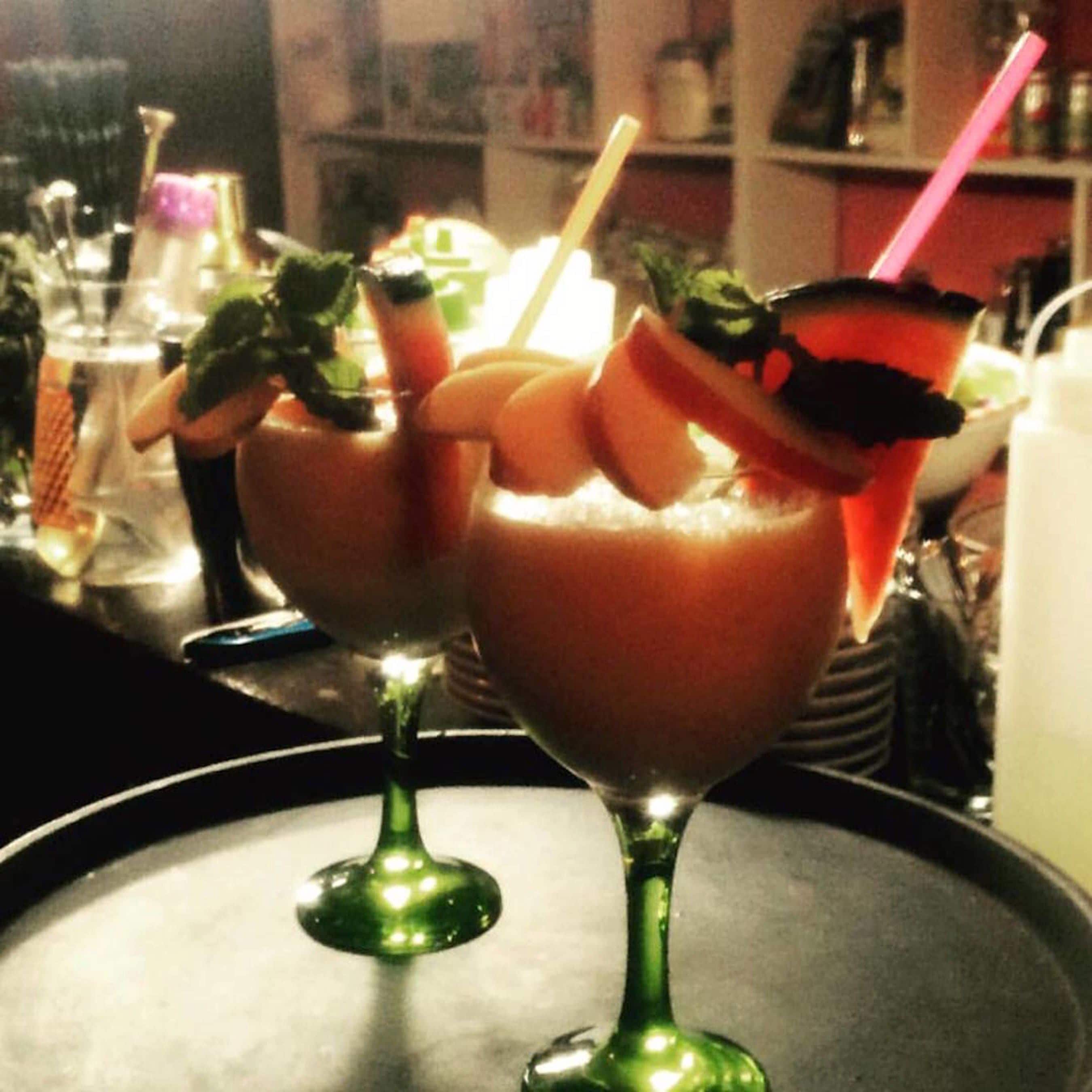Two cocktails in stemmed glasses on a tray.