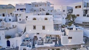 Un edificio blanco con piscina, zona de estar al aire libre y una escalera.
