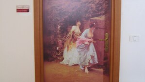 A door with a vintage painting of two women in period clothing. - Art Hotel (Villetta Barrea)