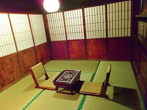 A tatami room with a low table and four chairs.