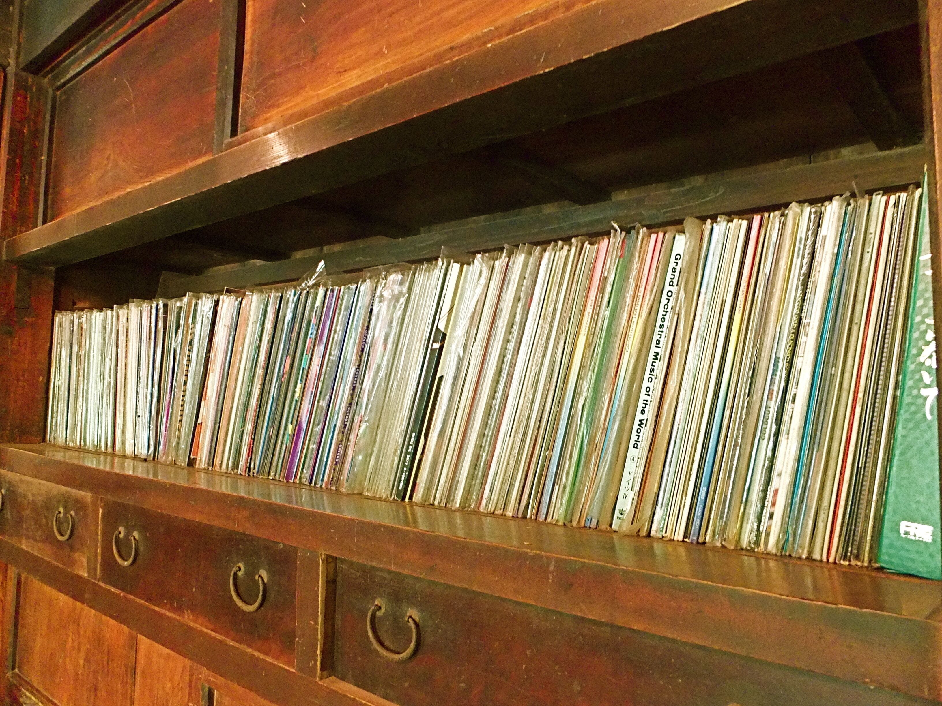A wooden shelf with multiple rows of CDs/DVDs.