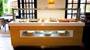 A buffet counter with various food items and a glass display case. - Paraíso de los Pinos Apartamentos (Formentera)