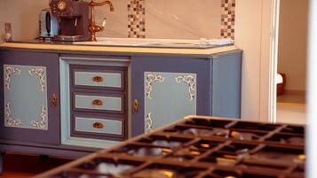 Una cocina con estufa de estilo vintage, cafetera y salpicadero de azulejos.