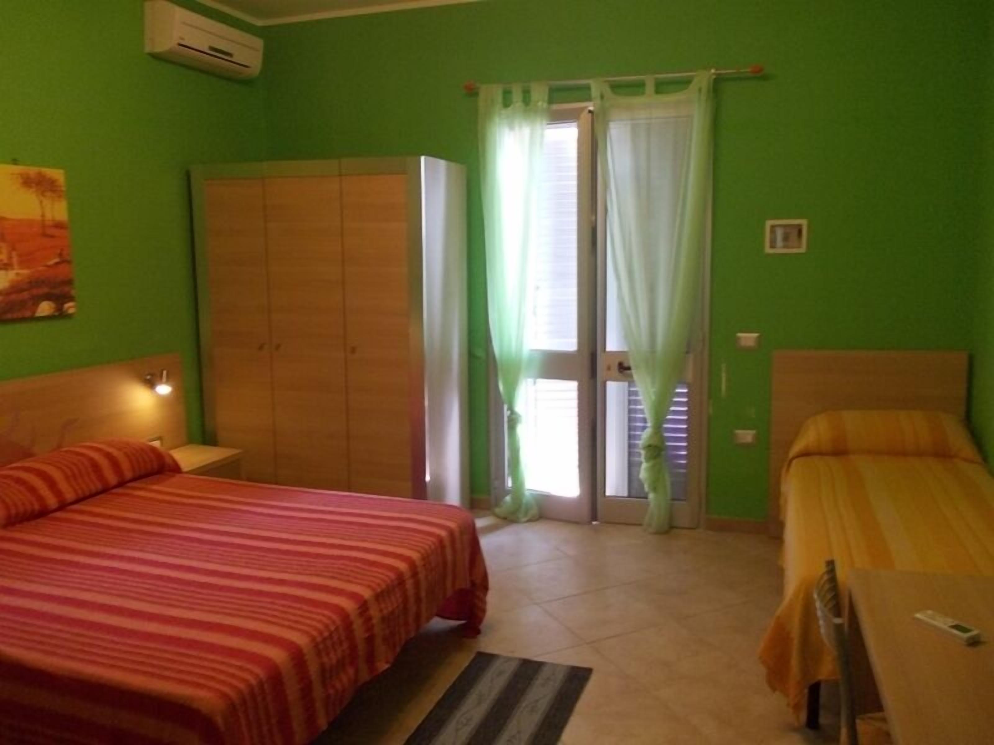 Una habitación con dos camas, un armario, una mesa y una silla.