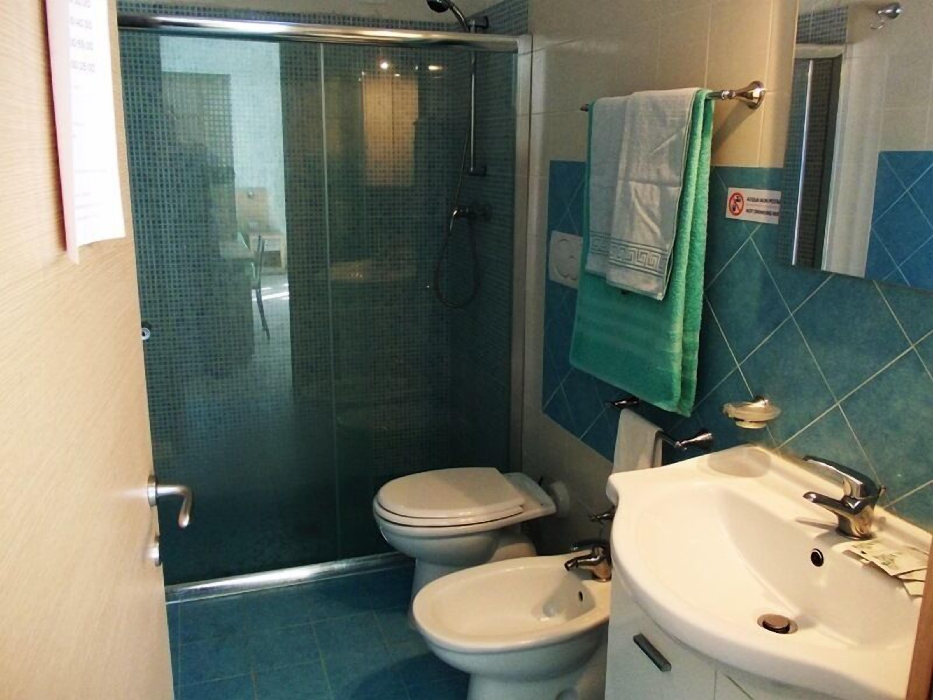Un baño con ducha de vidrio, inodoro, bidé y lavamanos.