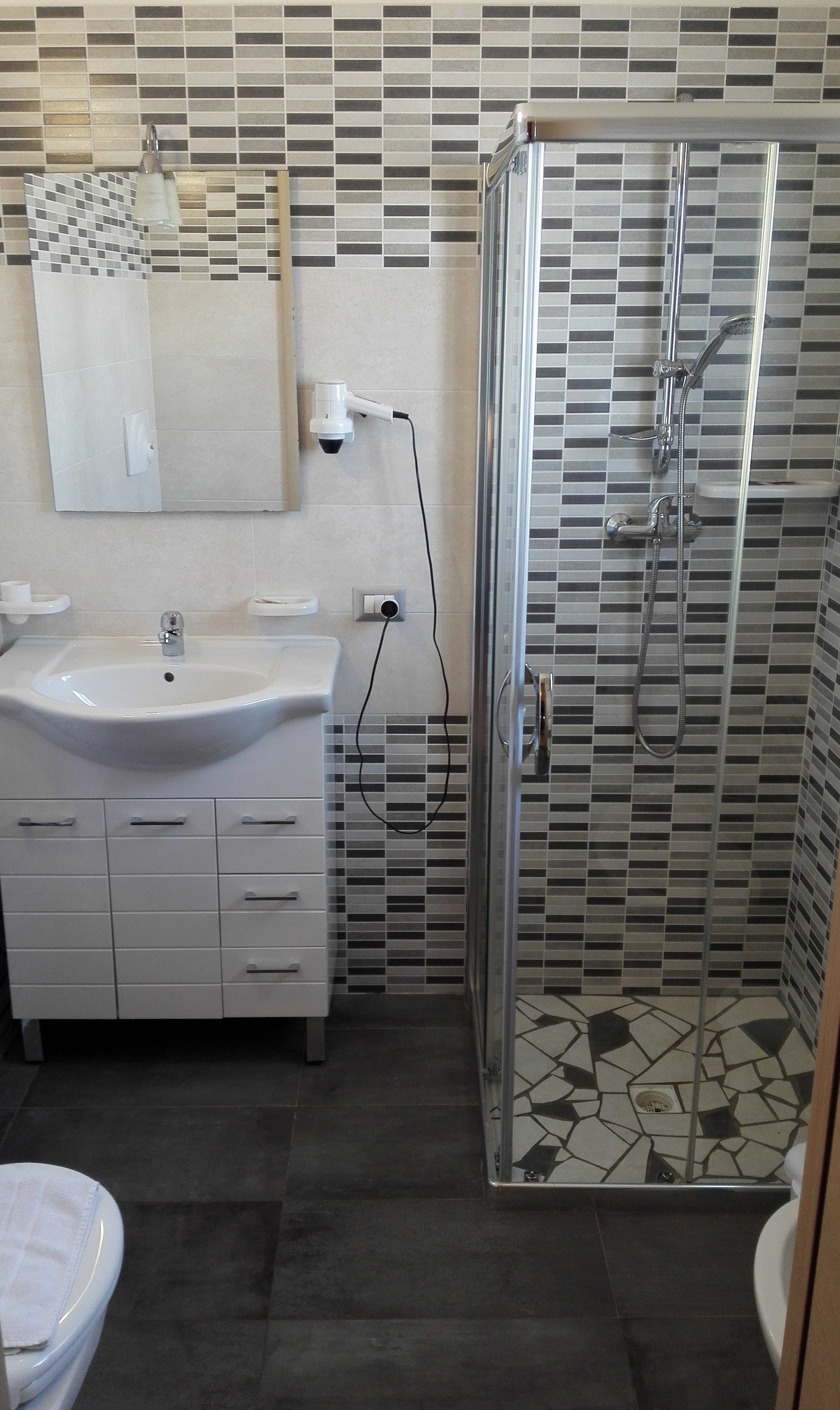 Une salle de bain avec un lavabo, un miroir et une douche.