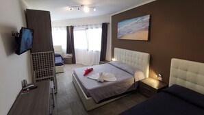 A modern hotel room with a large bed, a flat-screen TV, a desk with a computer, and a painting on the wall. - Samanà Bed (Porto Cesareo)