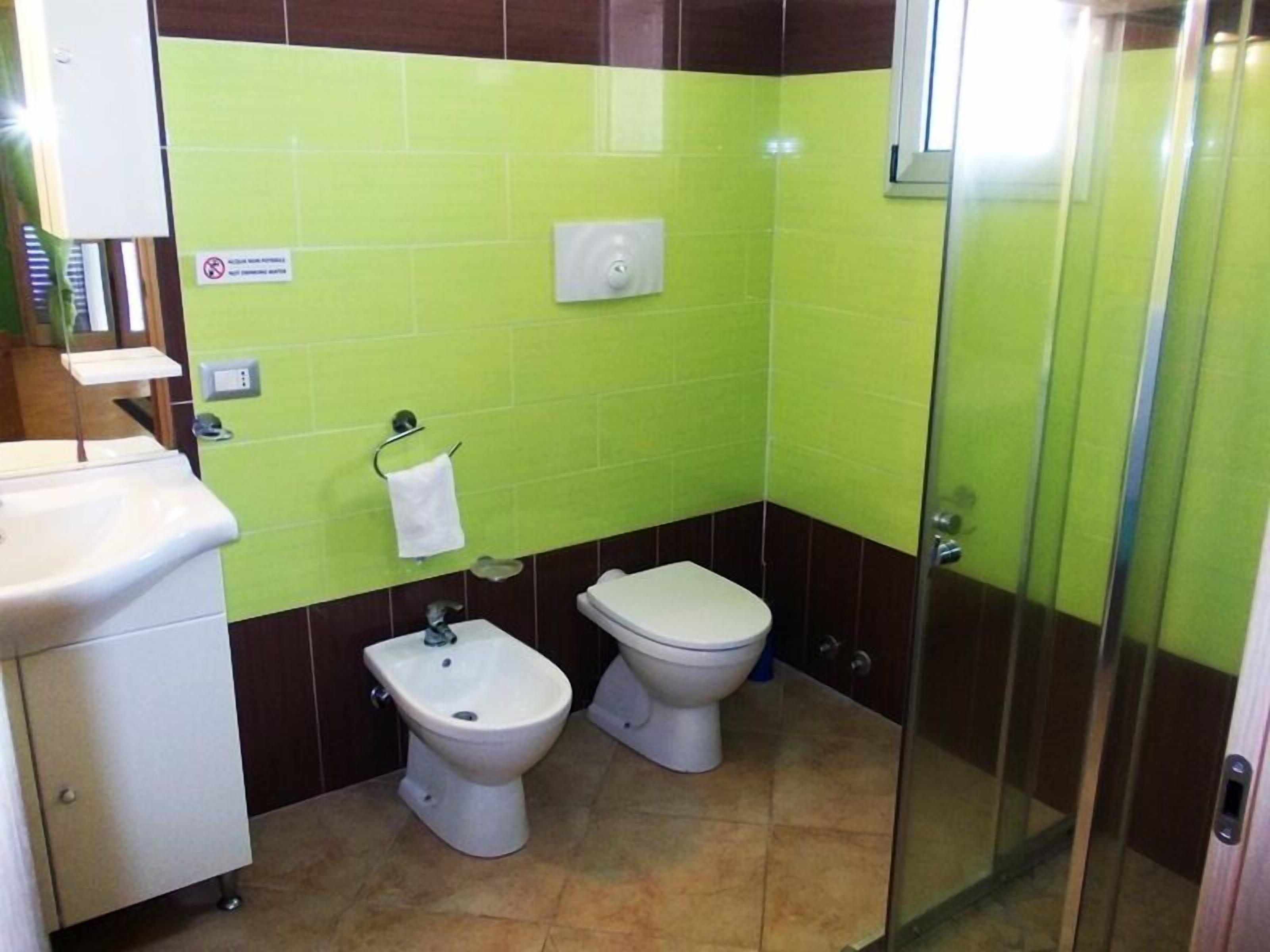 A bathroom with a bidet, toilet, and sink.