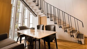 A modern interior with a staircase, a dining area, and large windows. - Townhouse PK Garden (Bangkok)