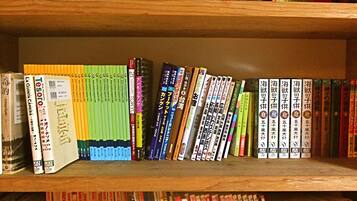 A bookshelf with various books, including travel guides and novels.