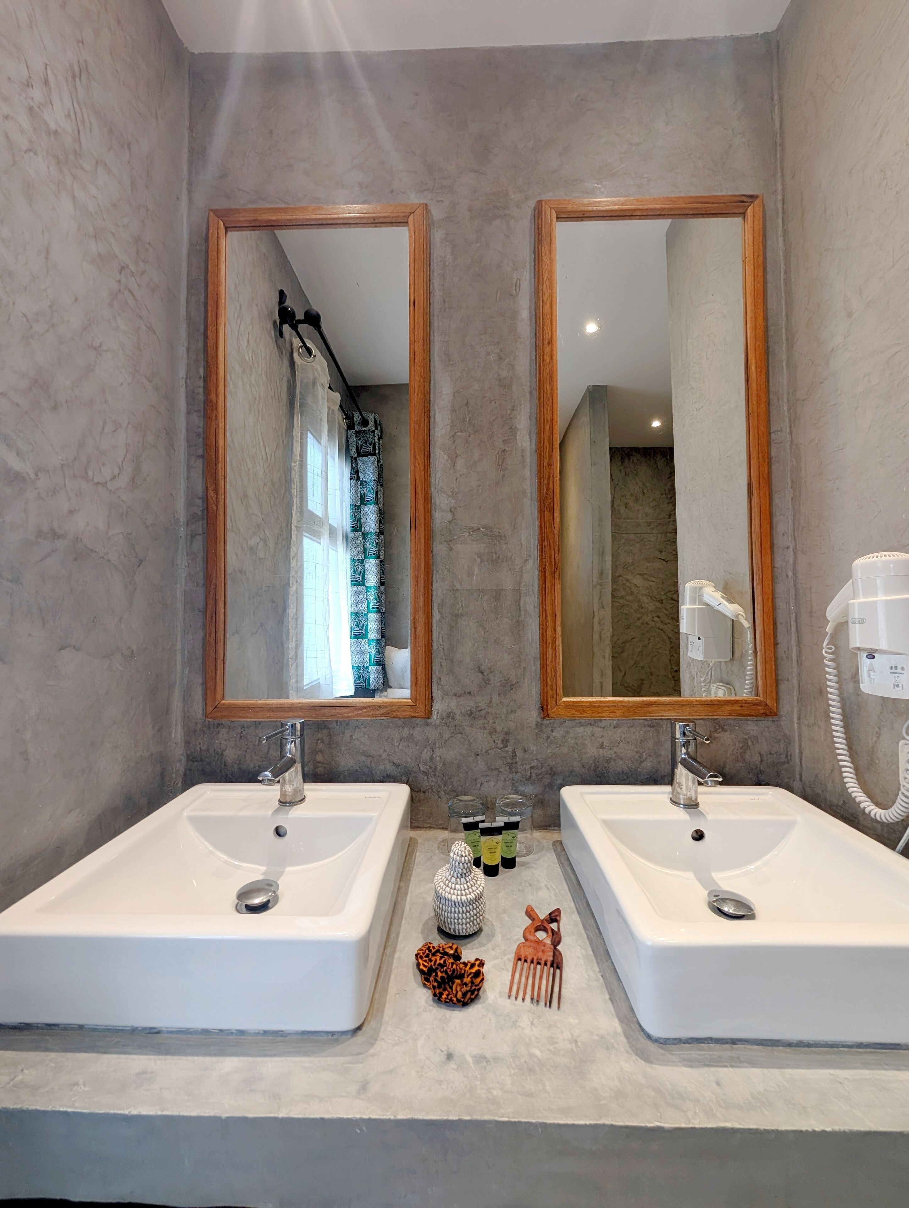 A bathroom with two sinks, large mirrors, and a hairdryer.