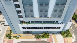Un moderno edificio de hotel con un llamativo letrero 'ghl Style Hotel', varios pisos y un jardín en la azotea.
