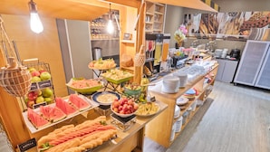 Un bufé con diversas frutas y platos.