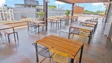 Enjoy al fresco dining under a shaded pergola with comfortable seating and lush greenery.