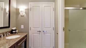 A bathroom with a double vanity, a large mirror, and a glass shower enclosure.