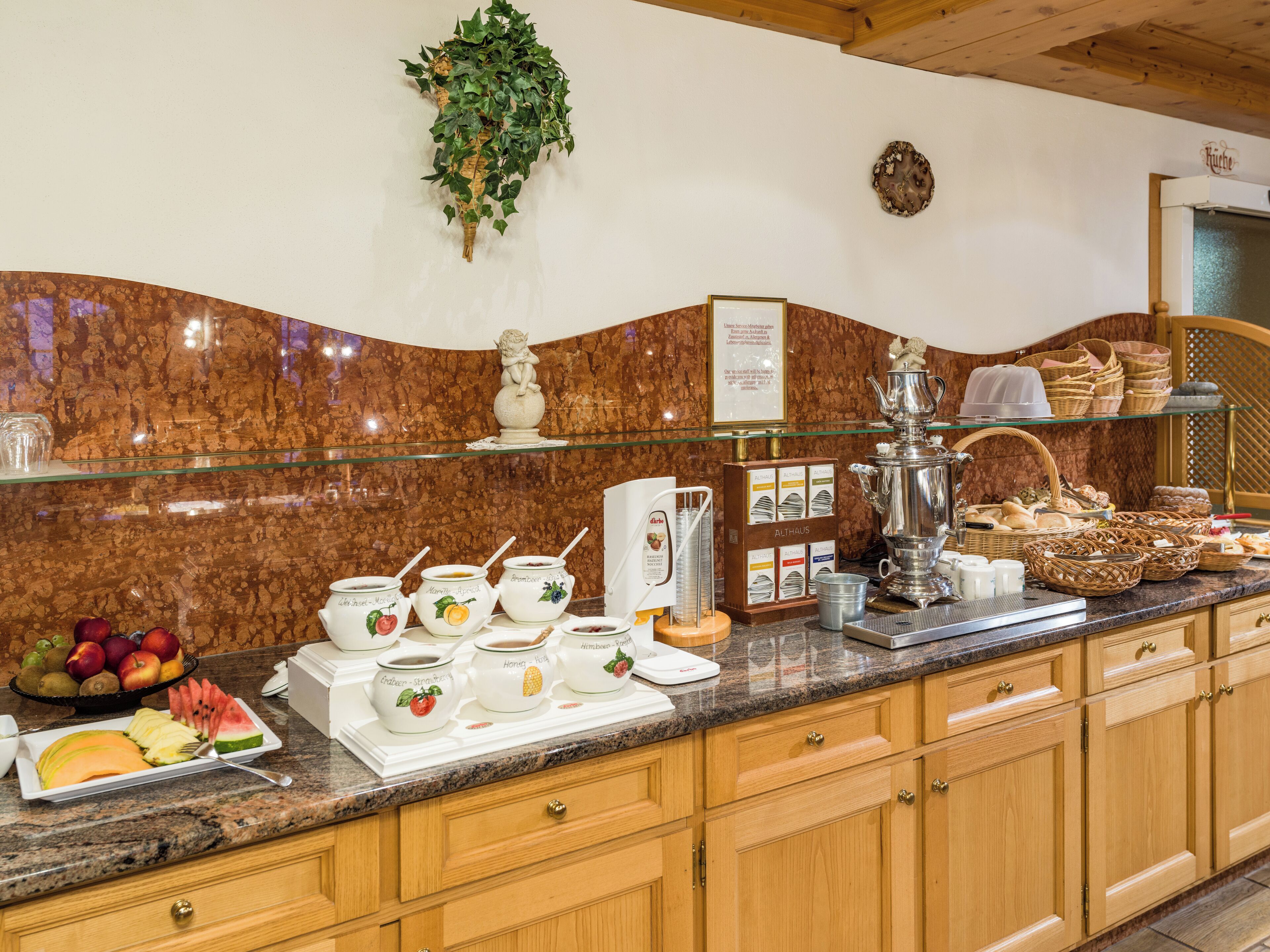 A breakfast buffet with various food items and serving utensils.