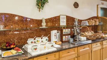 A breakfast buffet with various food items and serving utensils.