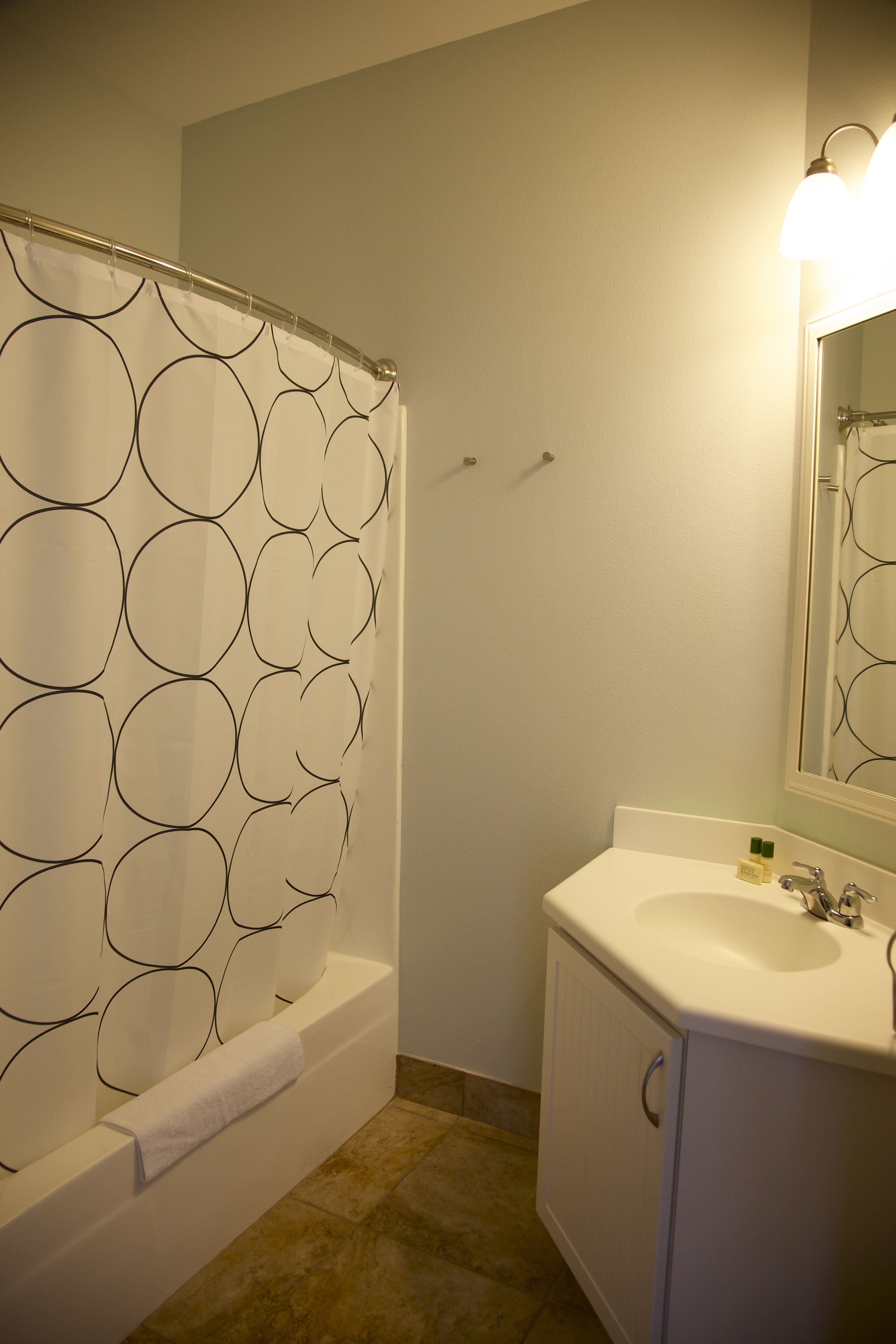 Une salle de bain avec une baignoire, un lavabo et un miroir.