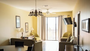 A hotel room with a dining area, two sofas, a table, and a TV. - The Citrus on the Lake (Tavares)