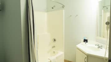 A bathroom with a shower, a sink, and a mirror.