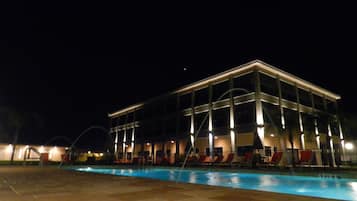 Un edificio moderno con piscina e lettini.