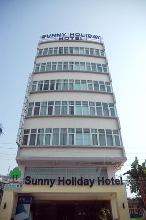 A multi-story building with the signage "Sunny Holiday Hotel" at the top and "Asia Hotels Group" at the bottom. - Sunny Holiday Hotel (Yangon)