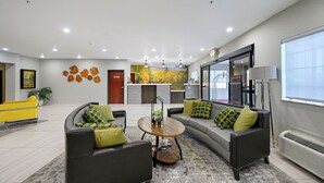 Un vestíbulo moderno con mostrador de recepción, zona de estar y un gran ventanal.