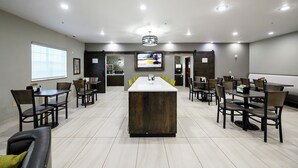 A conference room with a long table, multiple chairs, a large screen, and a modern ceiling design.