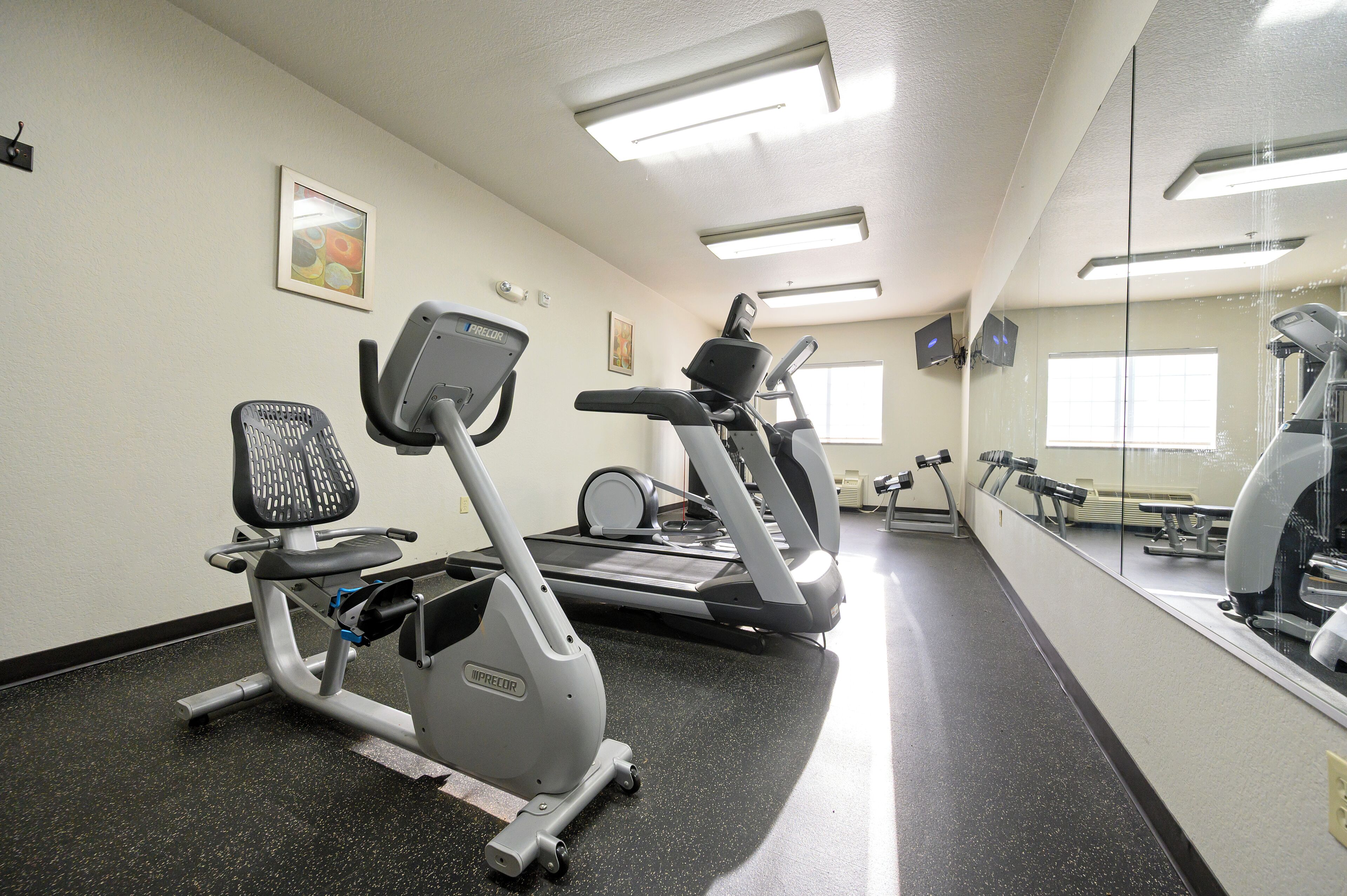A gym with stationary bikes, an elliptical, and a treadmill.