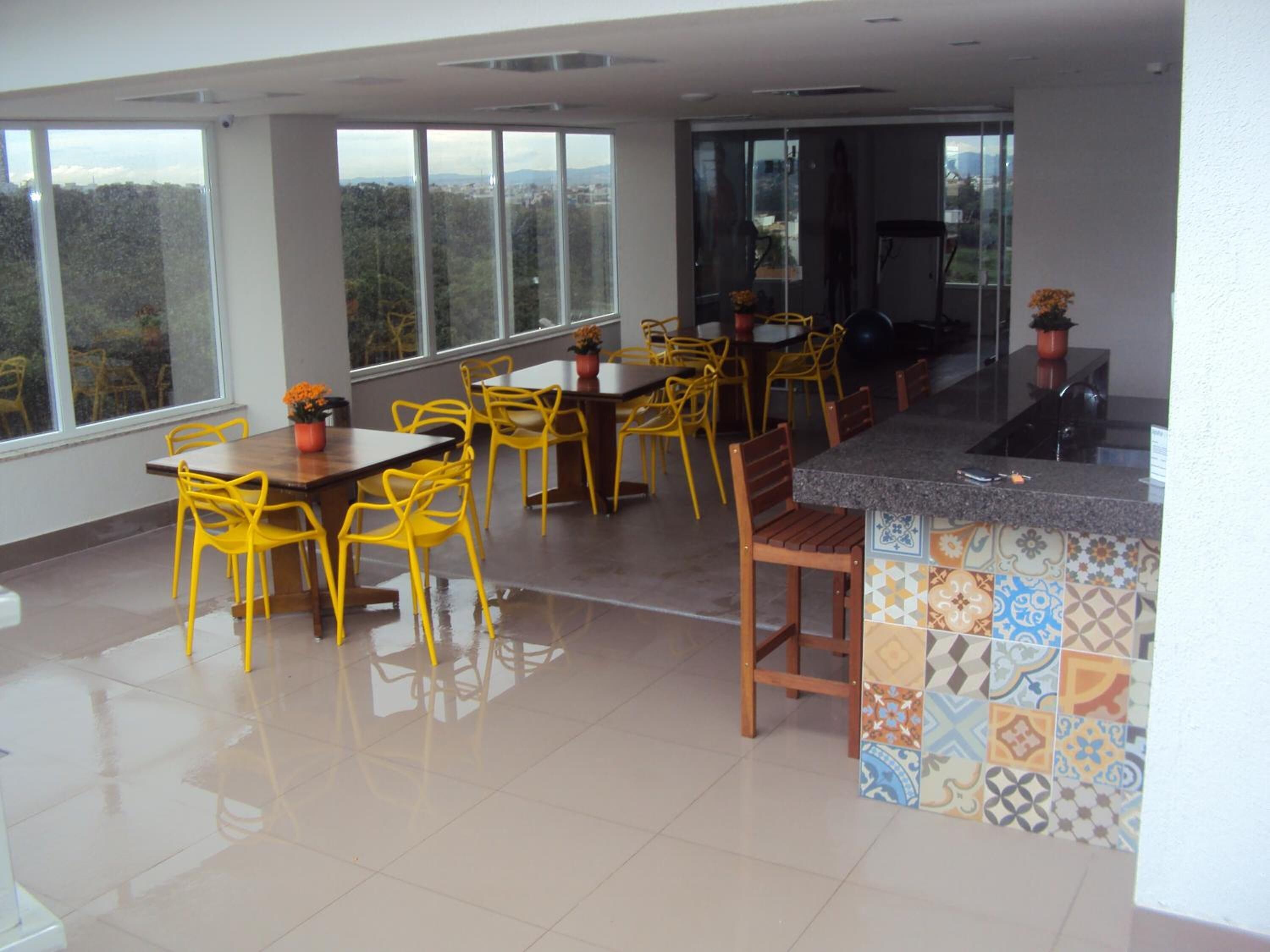 A spacious dining area with yellow chairs and a tiled backsplash.