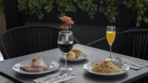 A table set with plates of food, wine glasses, and a glass of juice, surrounded by chairs. - Holiday Inn Express Mexico City Satelite by IHG (Naucalpan)