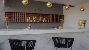 A modern bar area with marble countertops, black chairs, and a wooden wine rack. - Holiday Inn Express Mexico City Satelite by IHG (Naucalpan)