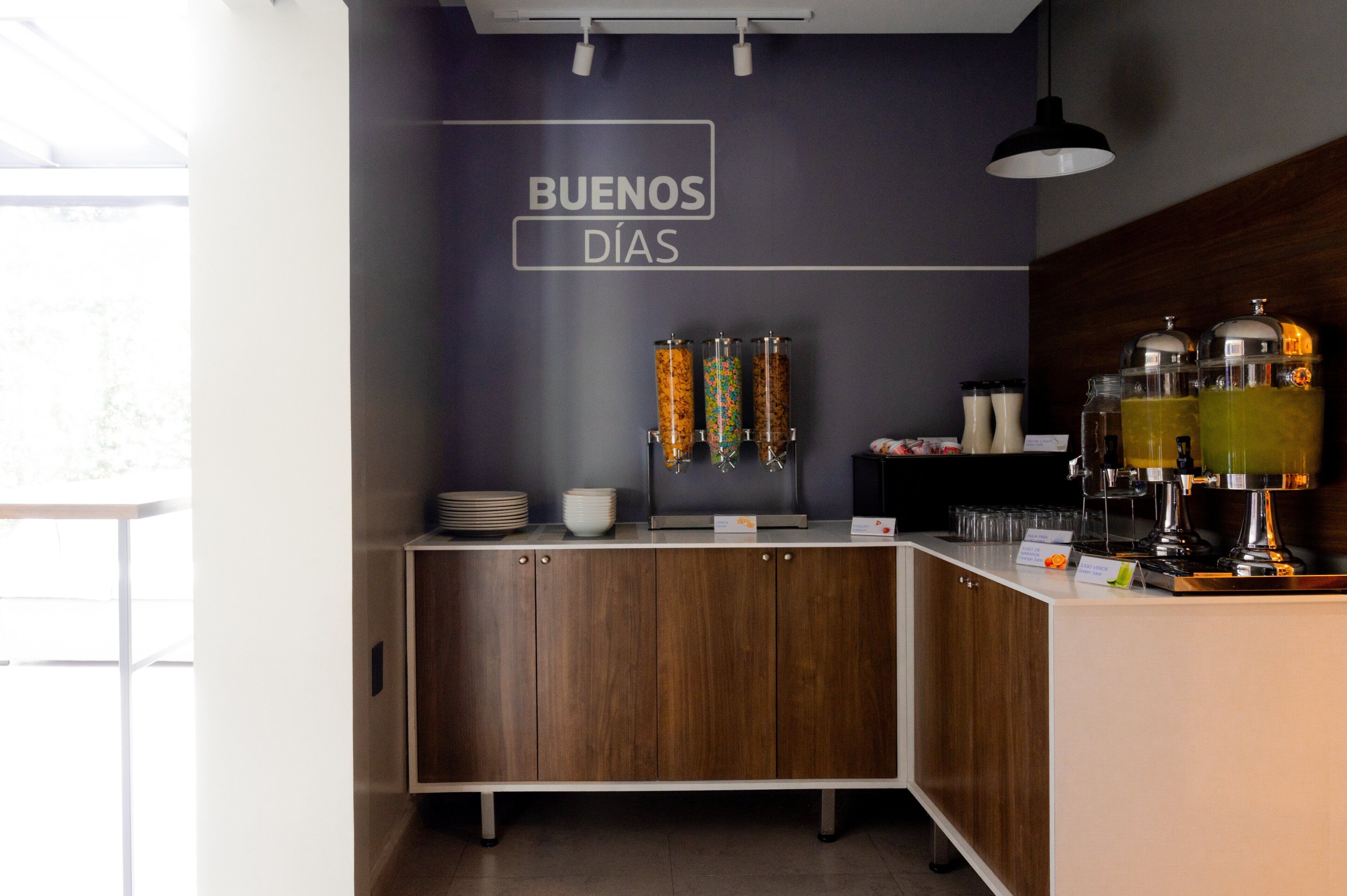 Zona cuina moderna amb taulell de fusta, una cafetera i un cartell que diu "BUENOS DÍAS".
