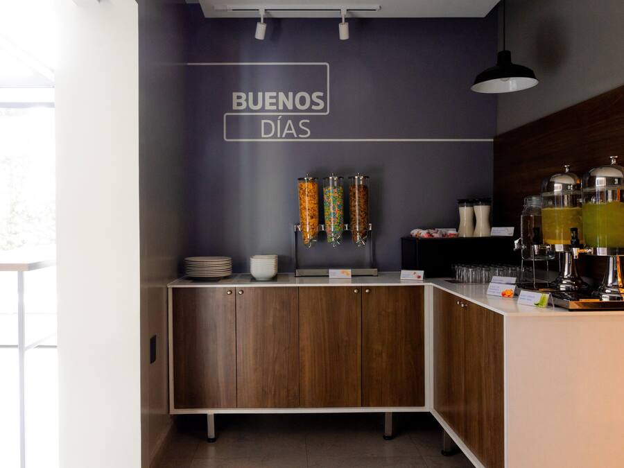 Zona cuina moderna amb taulell de fusta, una cafetera i un cartell que diu "BUENOS DÍAS".