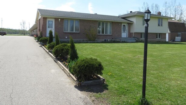 A two-story house with a front lawn and a driveway. - Newburg Inn Motel (Township of Wilmot)