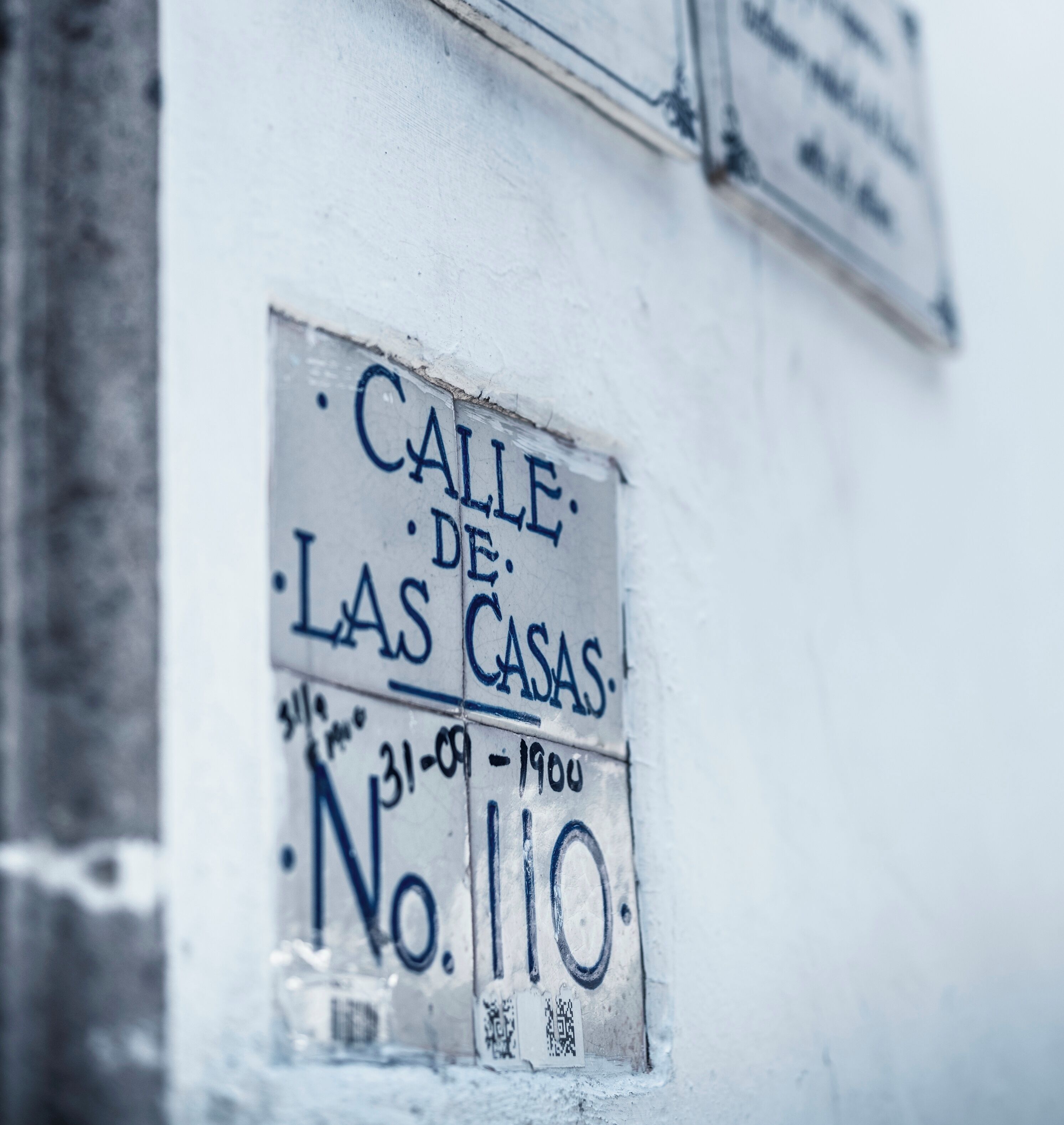 Una pared con un cartel que dice "Calle de las Casas" y el número "110".