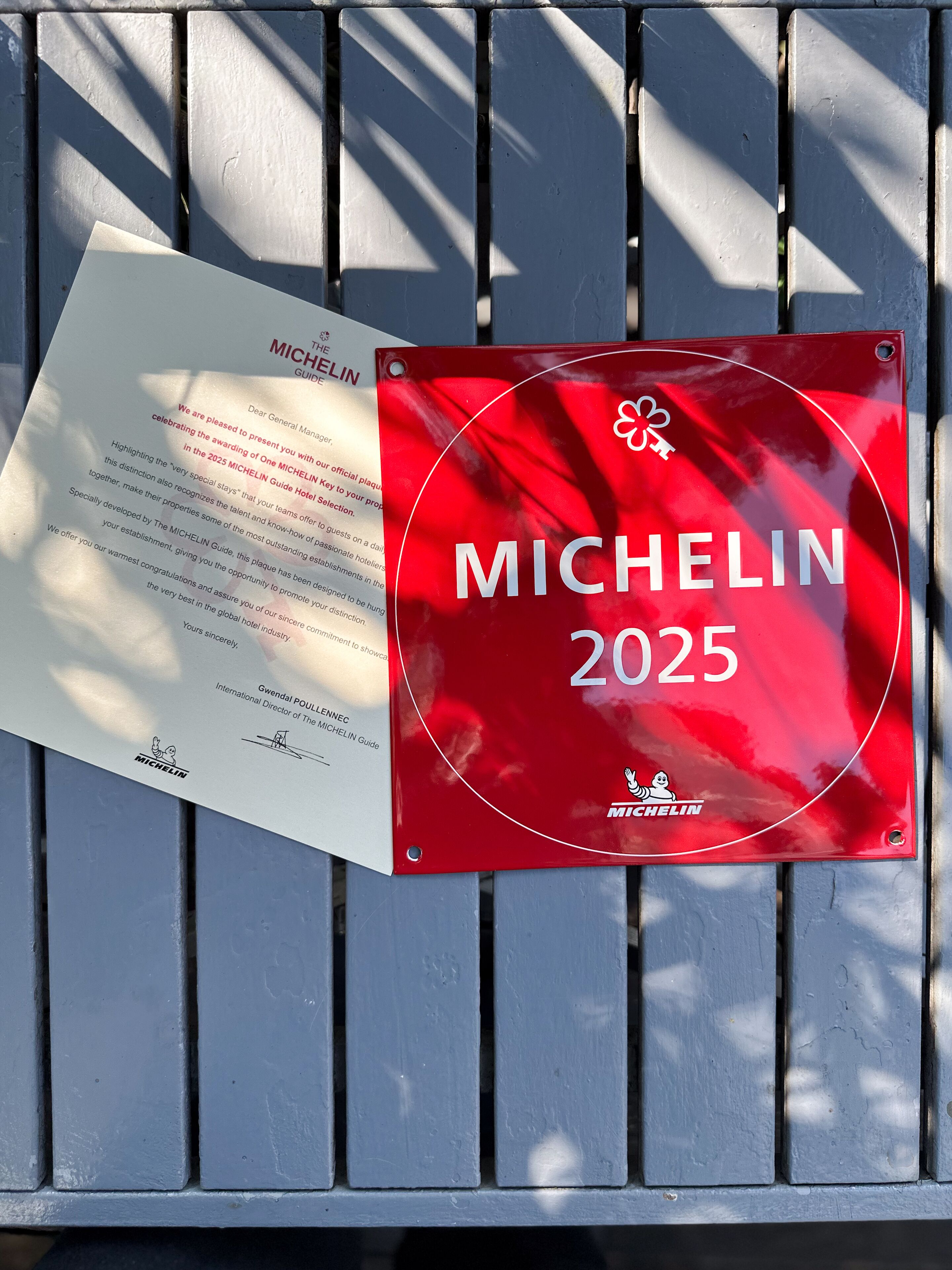 Une plaque fixée à un banc, avec un document à côté.