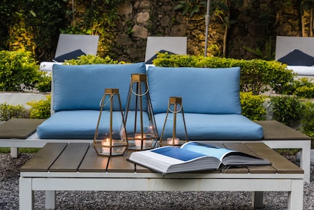 Una piscina al aire libre, sombrillas, sillones reclinables de piscina